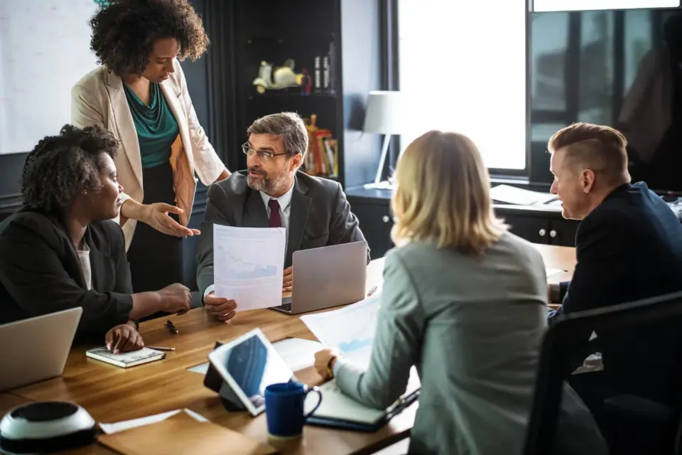 An advisory team reviewing reports with a client around a conference table